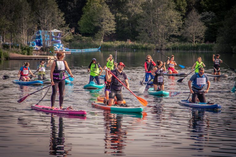 A group of people paddleboarding on a lake.